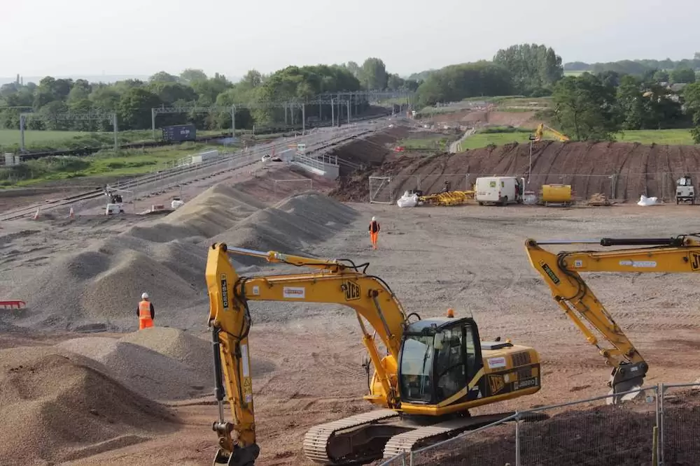 A time-lapse construction image of machinery assisting in pre-construction works at Norton Bridge.