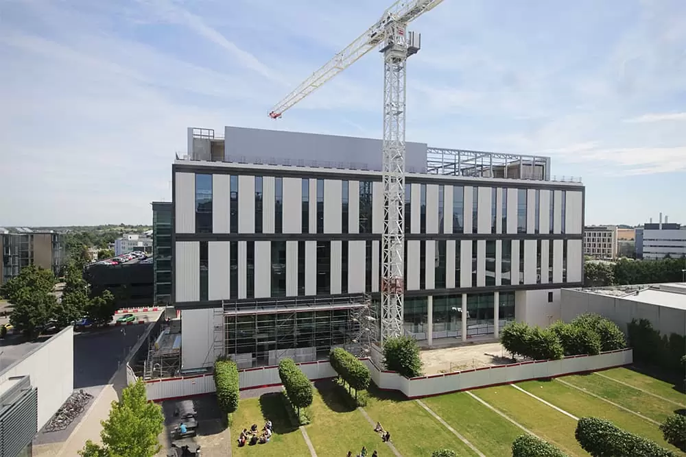 A Kier crane overhangs the completed Project Capella Building at the University of Cambridge Biomedical Campus