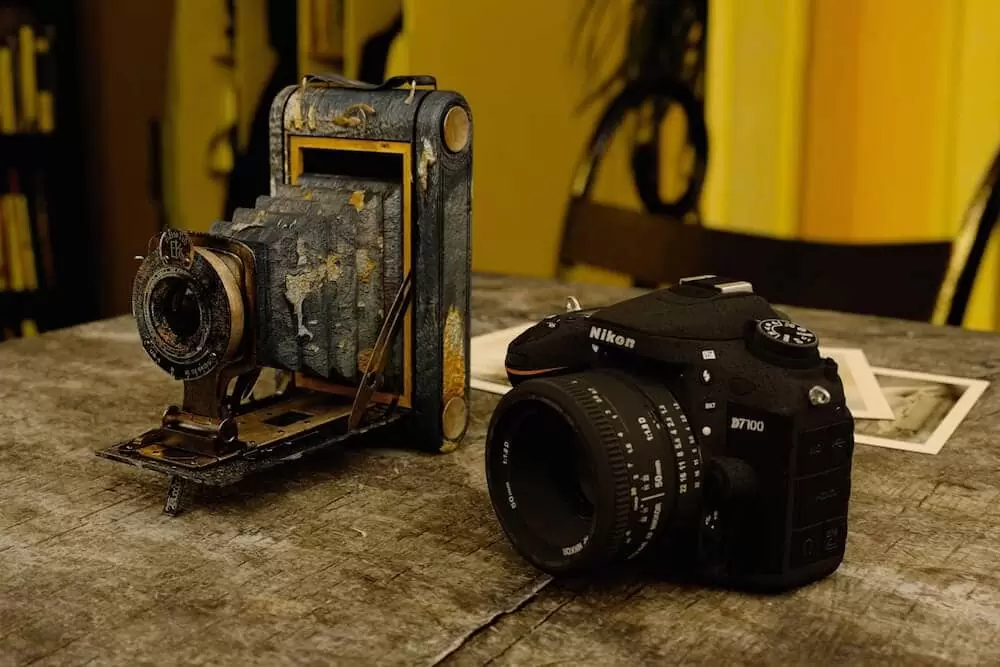 Image showing an analogue film camera alongside a modern DSLR.