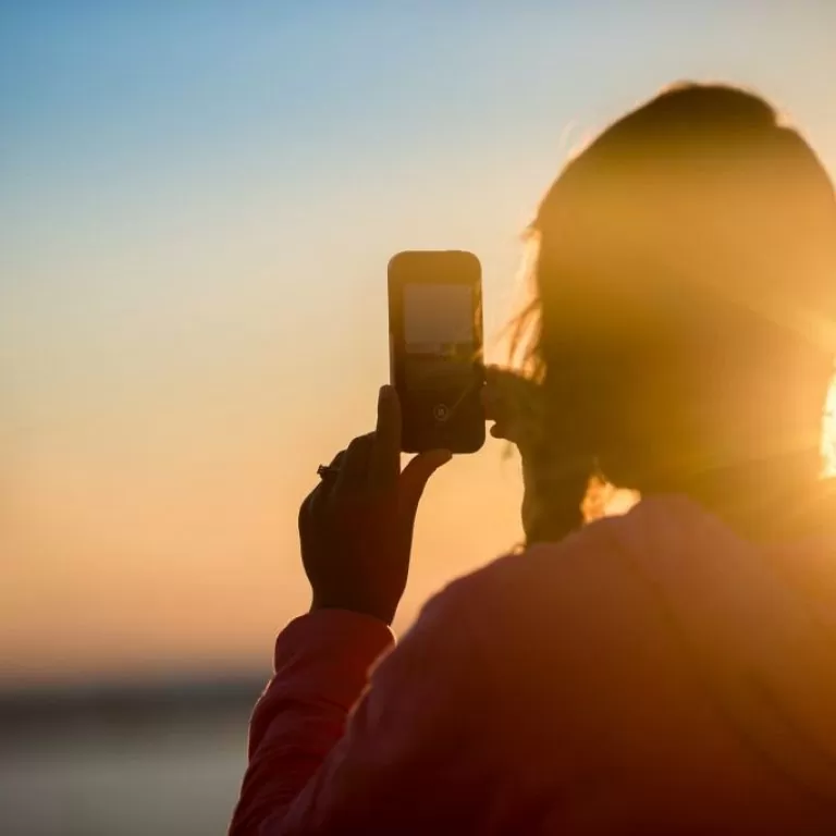 woman taking photo with smartphone