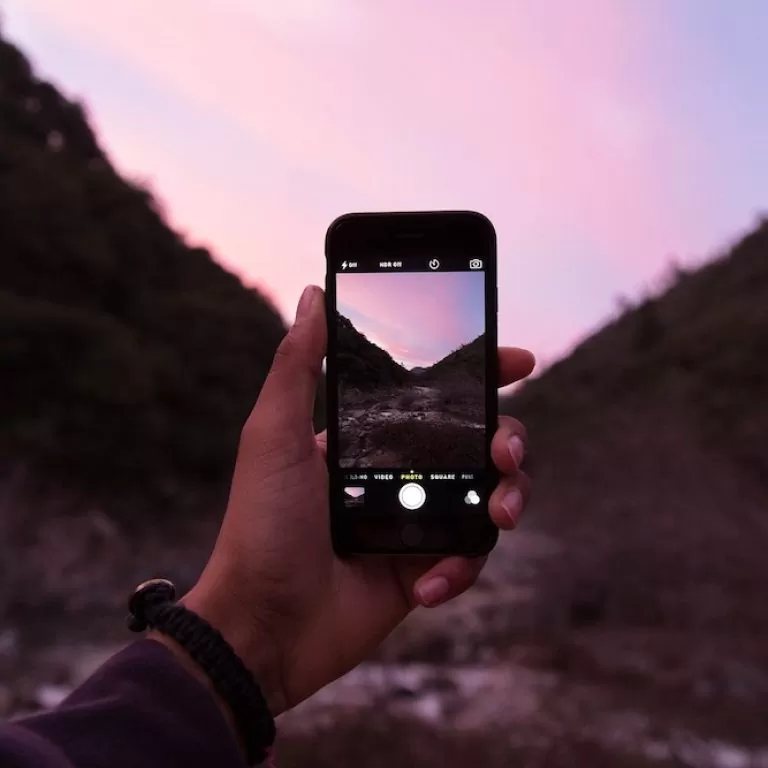 A smartphone pictured capturing a natural scene.