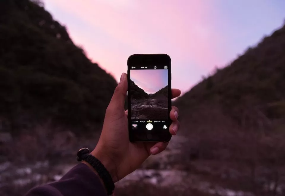 A smartphone pictured capturing a natural scene.