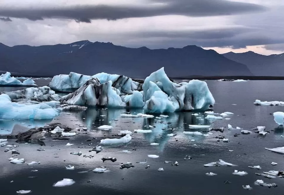 A cluster of floating glaciers with a stormy weather backdrop.