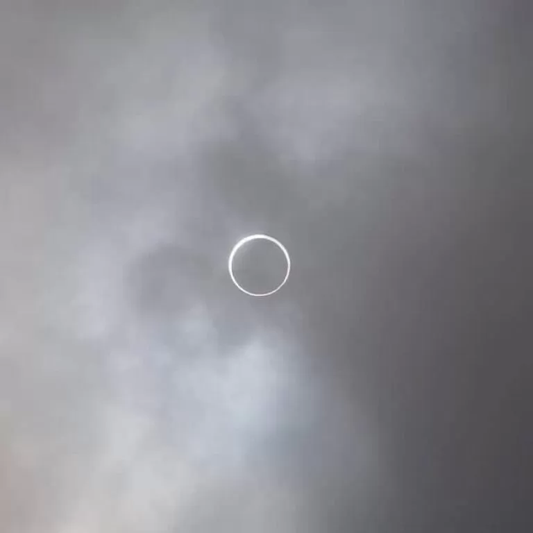 A solar eclipse in above a cloudy sky.