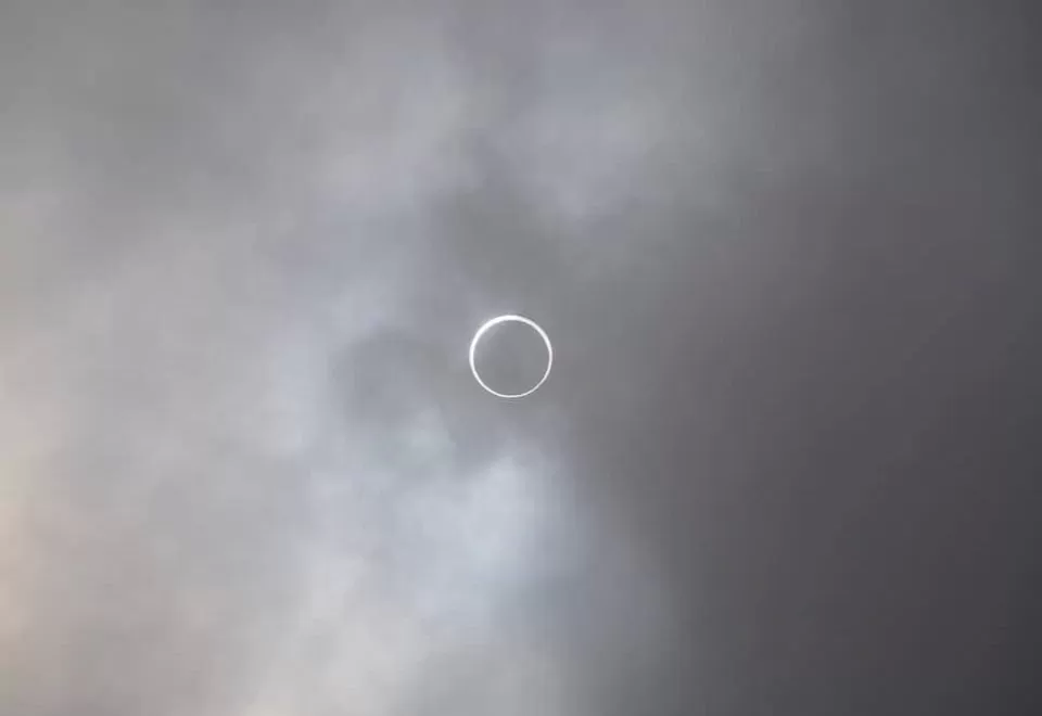 A solar eclipse in above a cloudy sky.