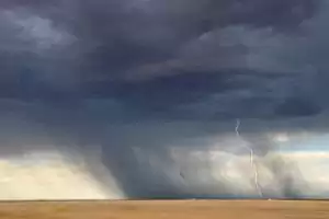 Lightning and storm clouds over a desolate landscape.