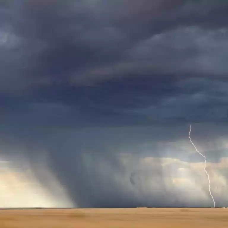 Lightning and storm clouds over a desolate landscape.