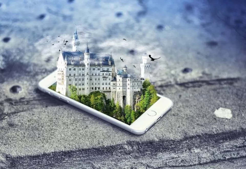 An idyllic castle emerging from the screen of an iPhone - depicting a virtual reality.