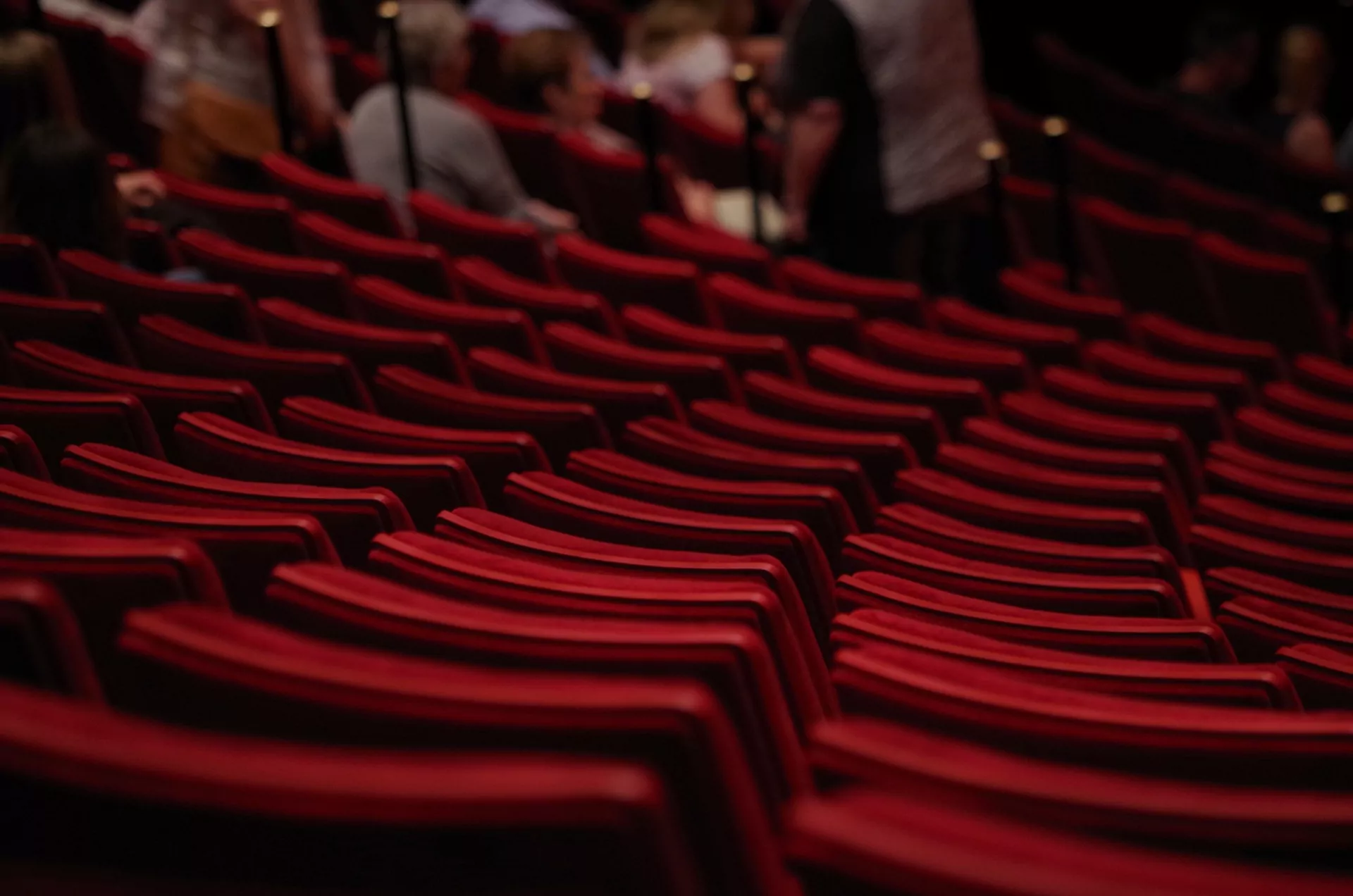 Rows of red velvet cinema chairs surrounding a stage. Time-lapse of theatres.