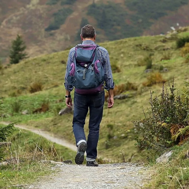 An image of a man on a hike walking on a path through rugged hills. The Time-Lapse of Walks and Hikes.